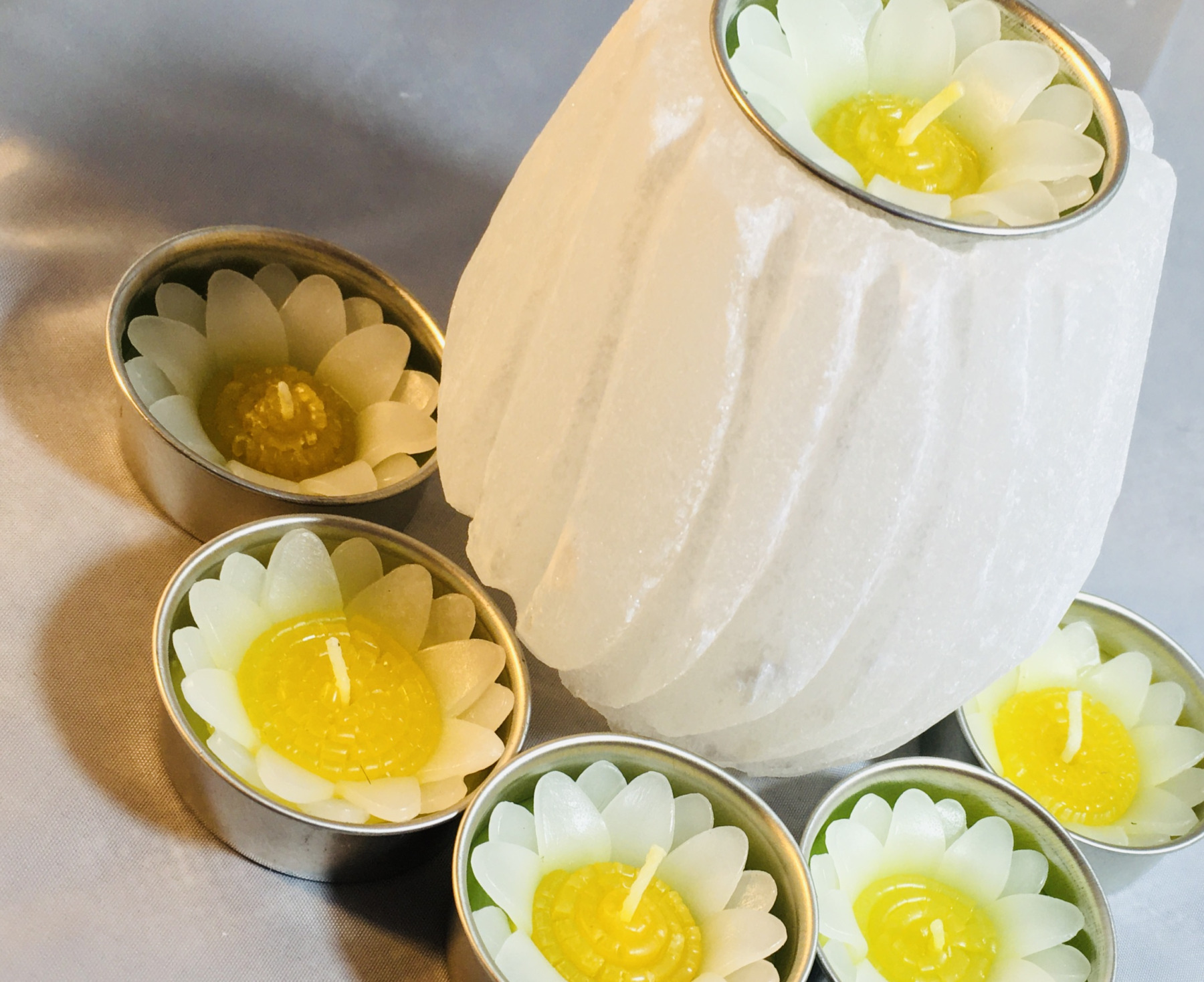Hand-carved selenite spiral tealight candle holder glowing with soft white crystal light
